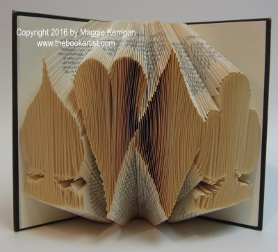 A book sculpture by Maggie Kerrigan that depicts the four suits from a deck of cards.