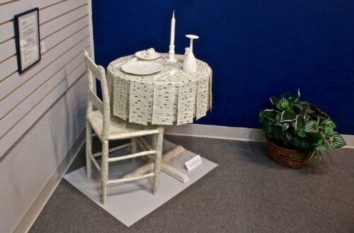 An artwork by Maggie Kerrigan that depicts the POW/MIA remembrance table made entirely out of paper.