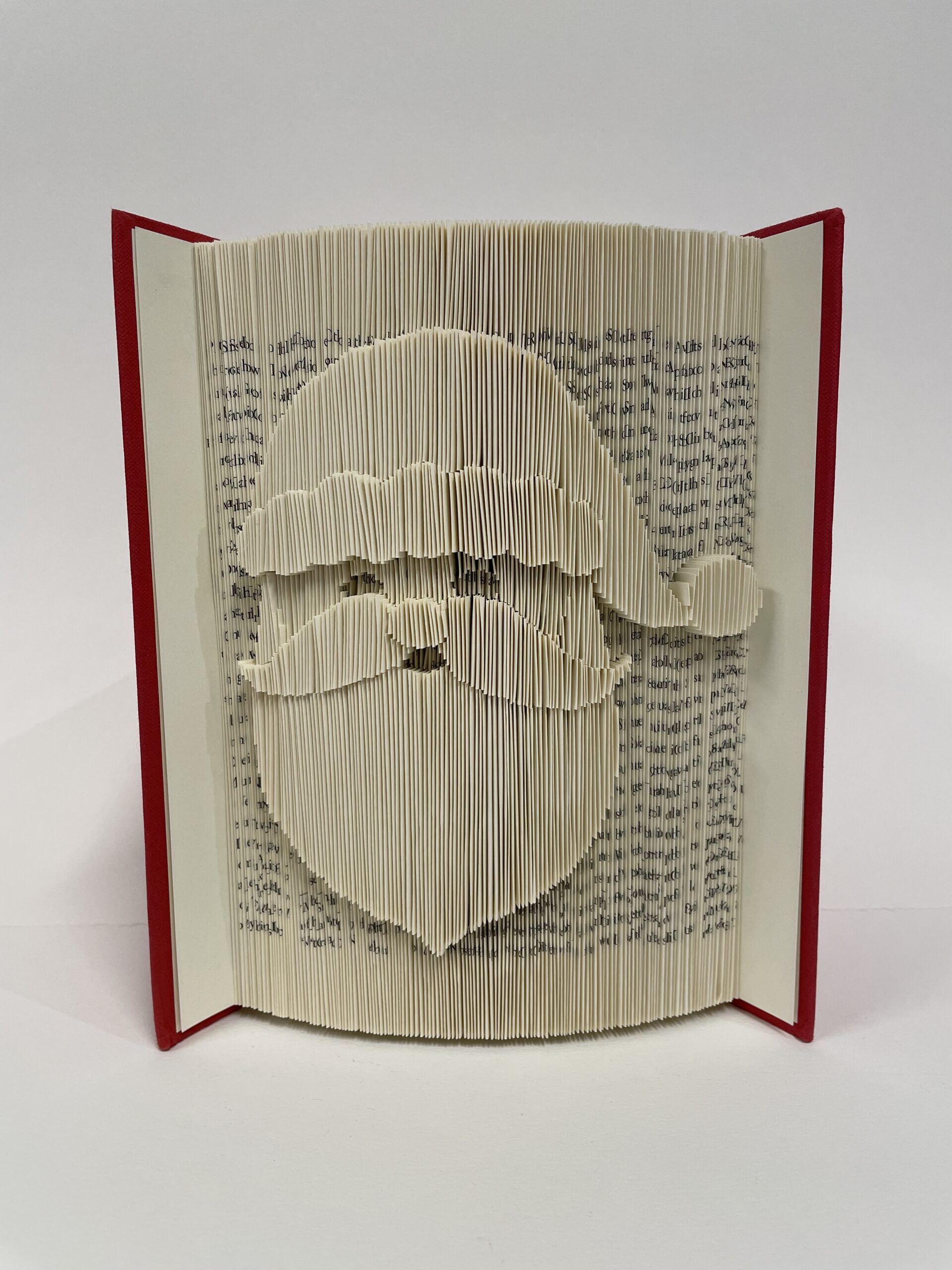 A book sculpture by Maggie Kerrigan in which the pages are folded to show an image of Santa Claus.