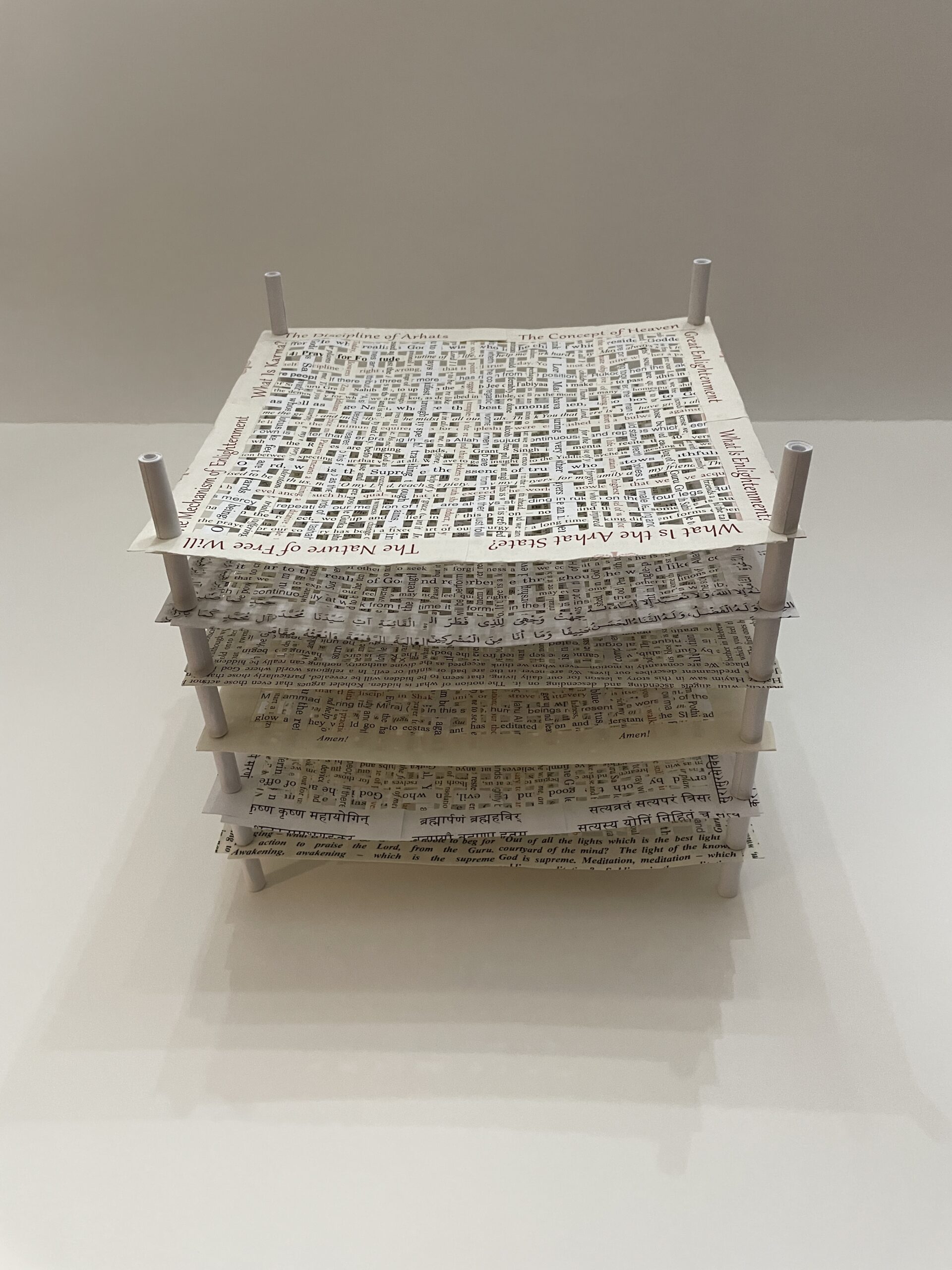 An artwork by Maggie Kerrigan that features layers of woven paper from books about world religions.