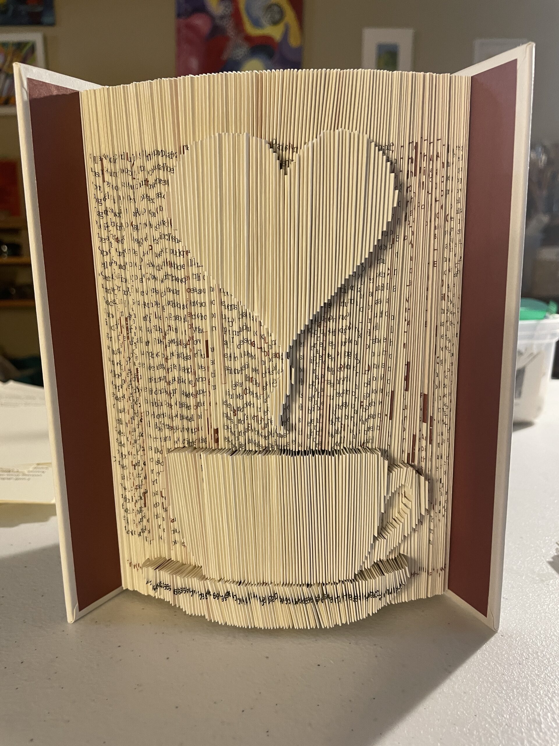 A book sculpture by Maggie Kerrigan that shows a cup of coffee with heart-shaped steam