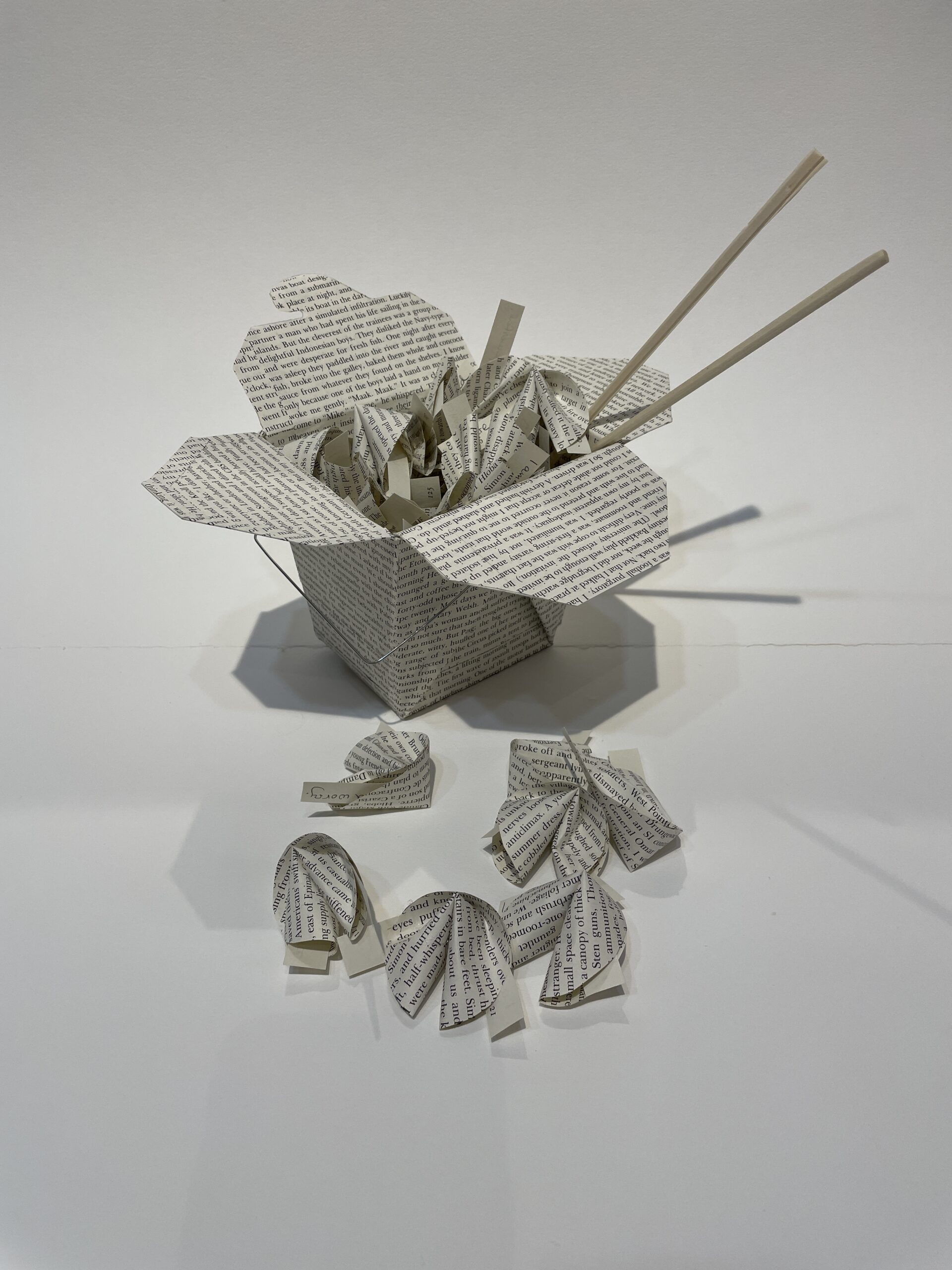 An artwork by Maggie Kerrigan that shows fortune cookies made from the paper of a book.