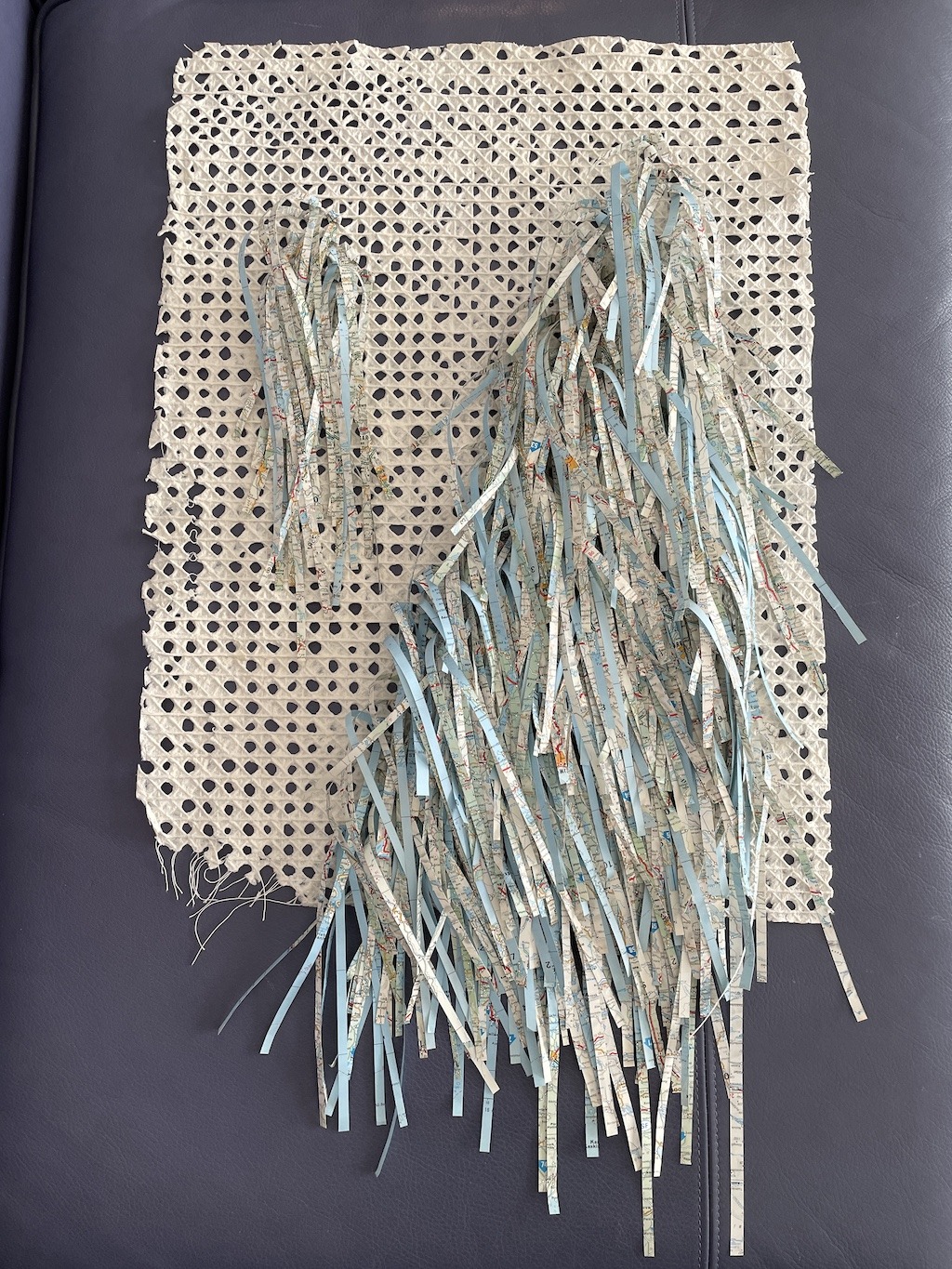 An artwork by Maggie Kerrigan that has shredded pages of a map woven into handmade paper