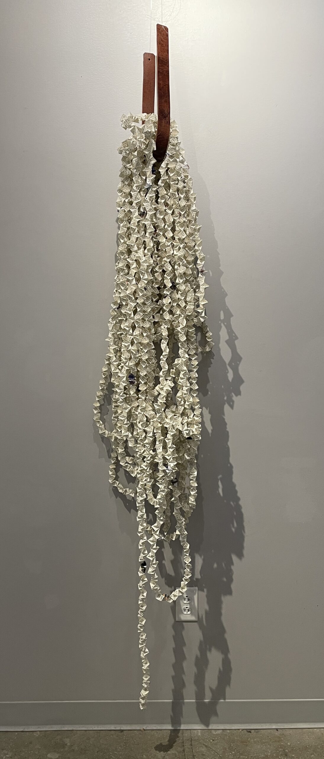 an artwork by Maggie Kerrigan consisting of hundreds of feet of paper chain made from the pages of a book