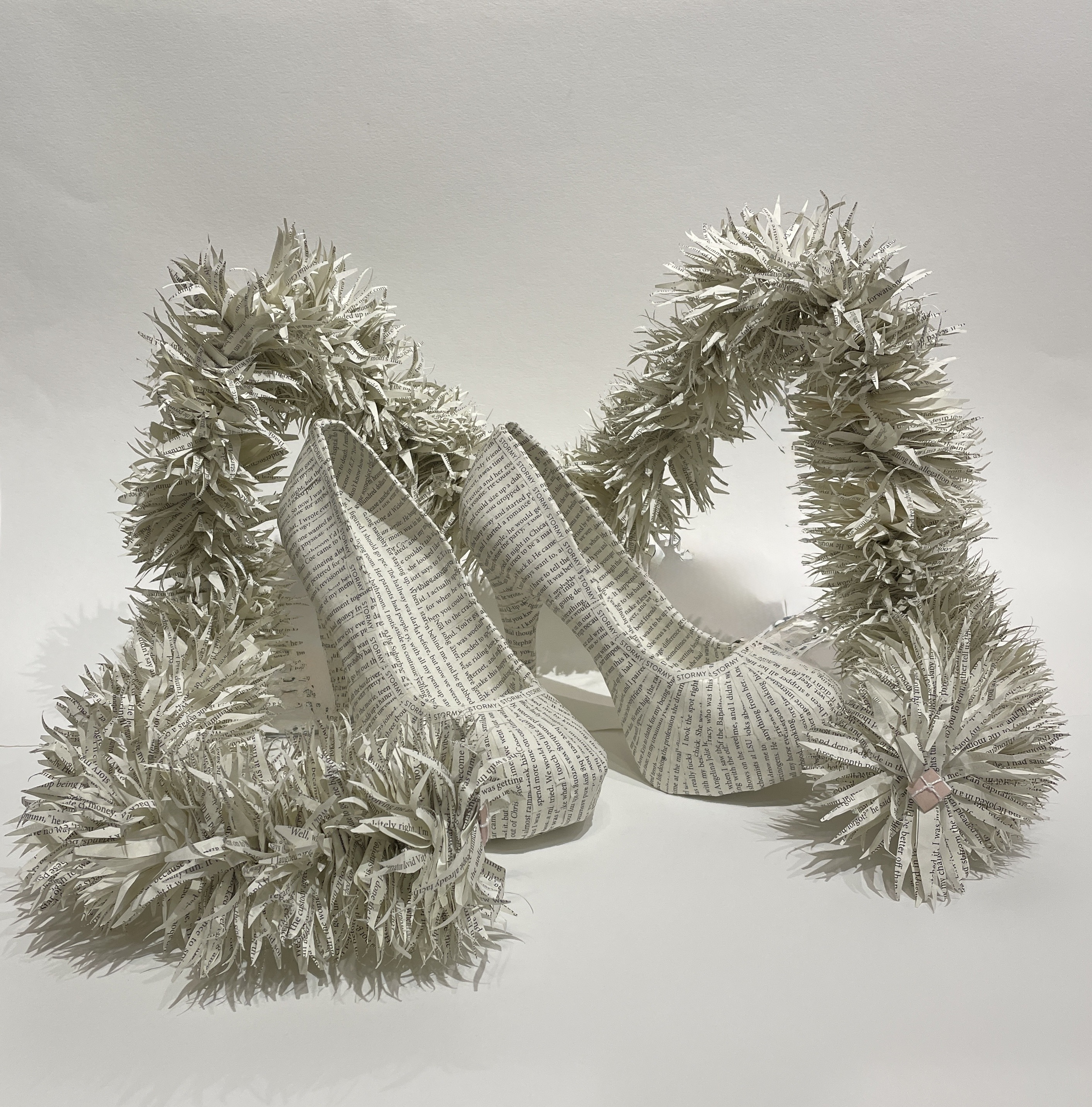 An artwork of a paper-cast pair of shoes and "feather boa" made by Virginia Beach artist Maggie Kerrigan from the book Full Disclosure by Stormy Daniels.