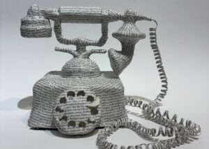 An artwork by Maggie Kerrigan of Virginia Beach. It is a paper-casted princess telephone covered in paper from the biography of Princess Diana.