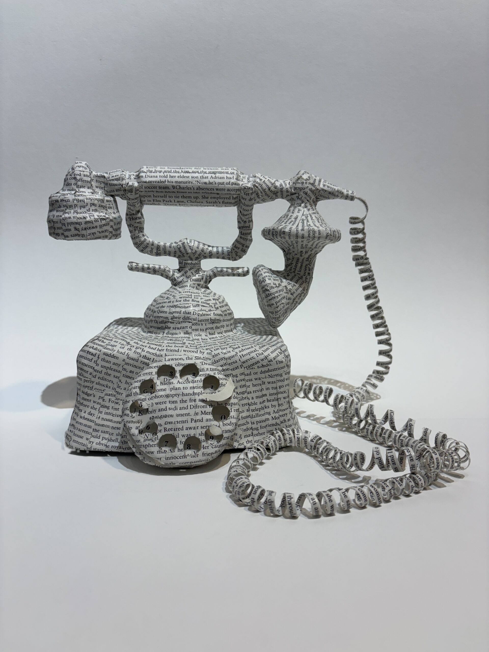 An artwork by Maggie Kerrigan of Virginia Beach. It is a paper-casted princess telephone covered in paper from the biography of Princess Diana.